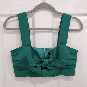 Green bustier crop top with bow detail and decorative silver zipper.